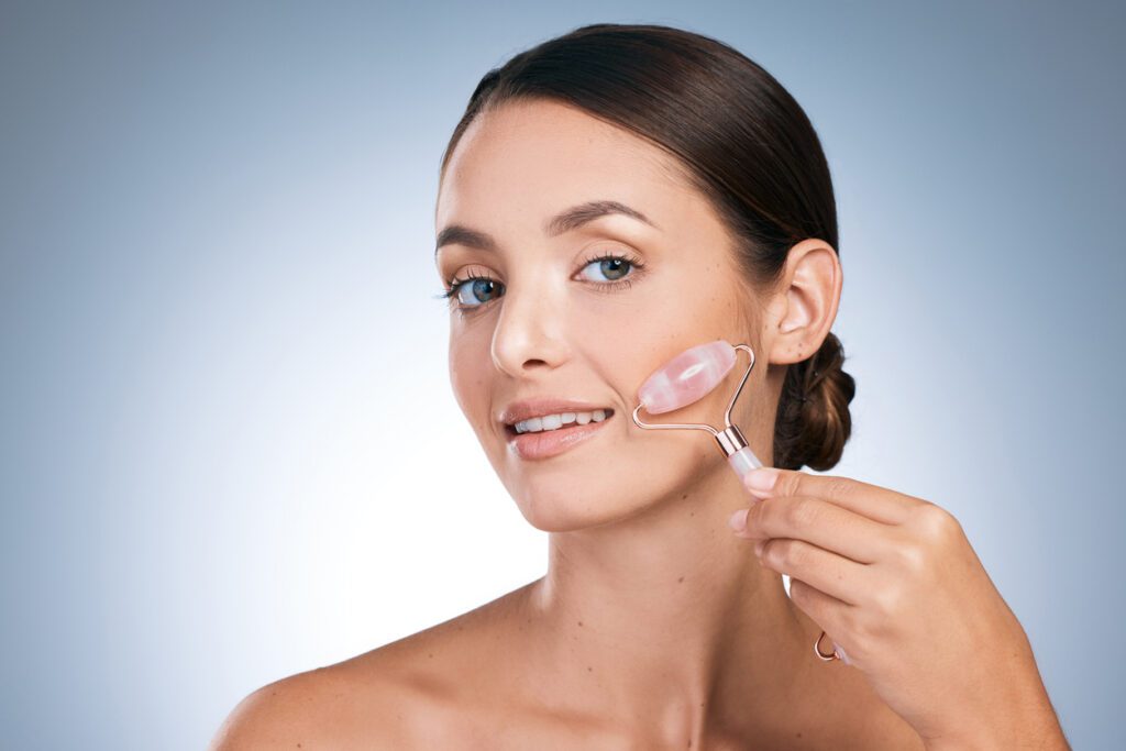 Portrait of an attractive young woman using a derma roller against against a blue background Tell the sun, get up outta my shade 20-24 Years Stock Photo